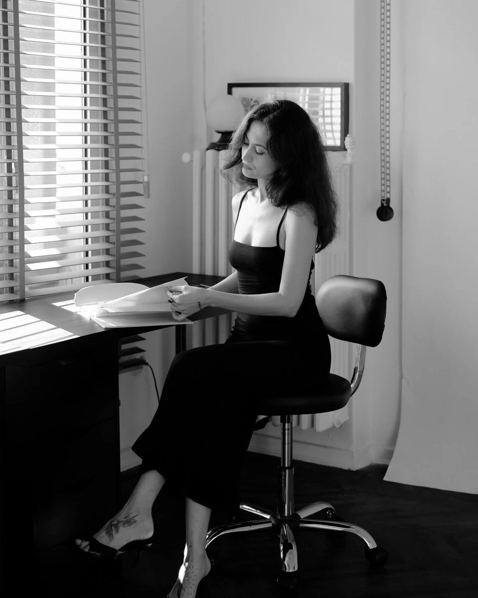 Pınar at her desk, looking through a sketchbook